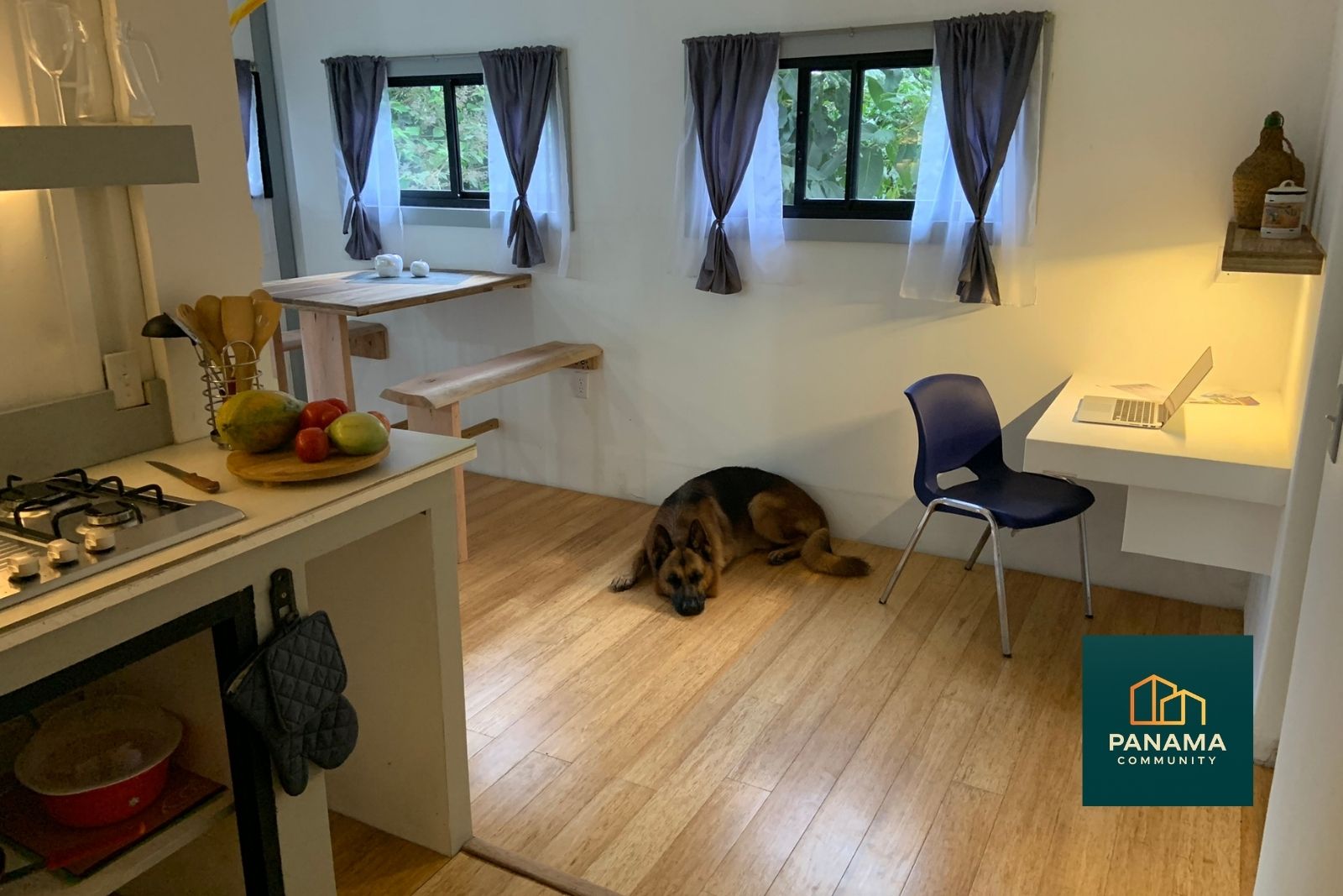 Wohnbereich in Apartment 3 mit offener Küche, Essplatz, Arbeitsplatz am Fenster und Blick ins Grüne. Ruhige, gelebte Atmosphäre.