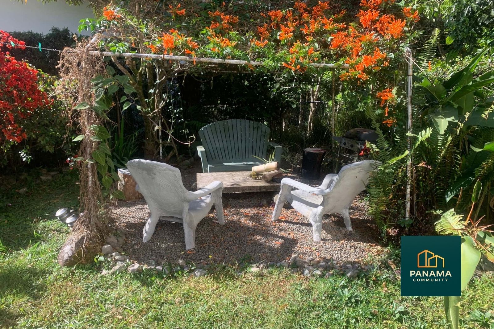 Sitzplatz im Garten des Refugio de Palmira im Hochland von Panama mit Stühlen unter blühenden Pflanzen.