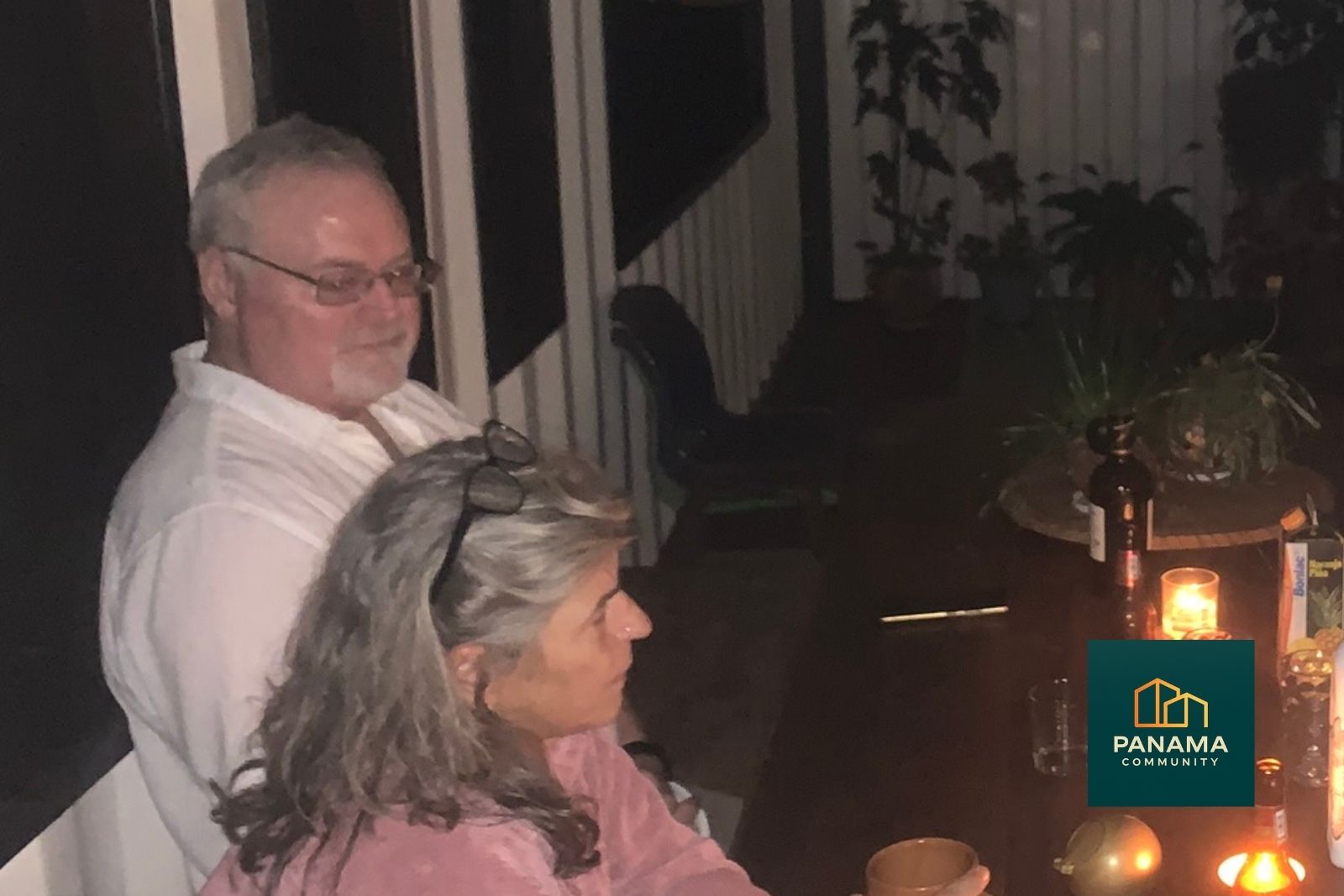 John John, Dauermieter der Panama Community, sitzt abends mit anderen Bewohnern bei Kerzenschein auf der Terrasse im Hochland von Boquete.