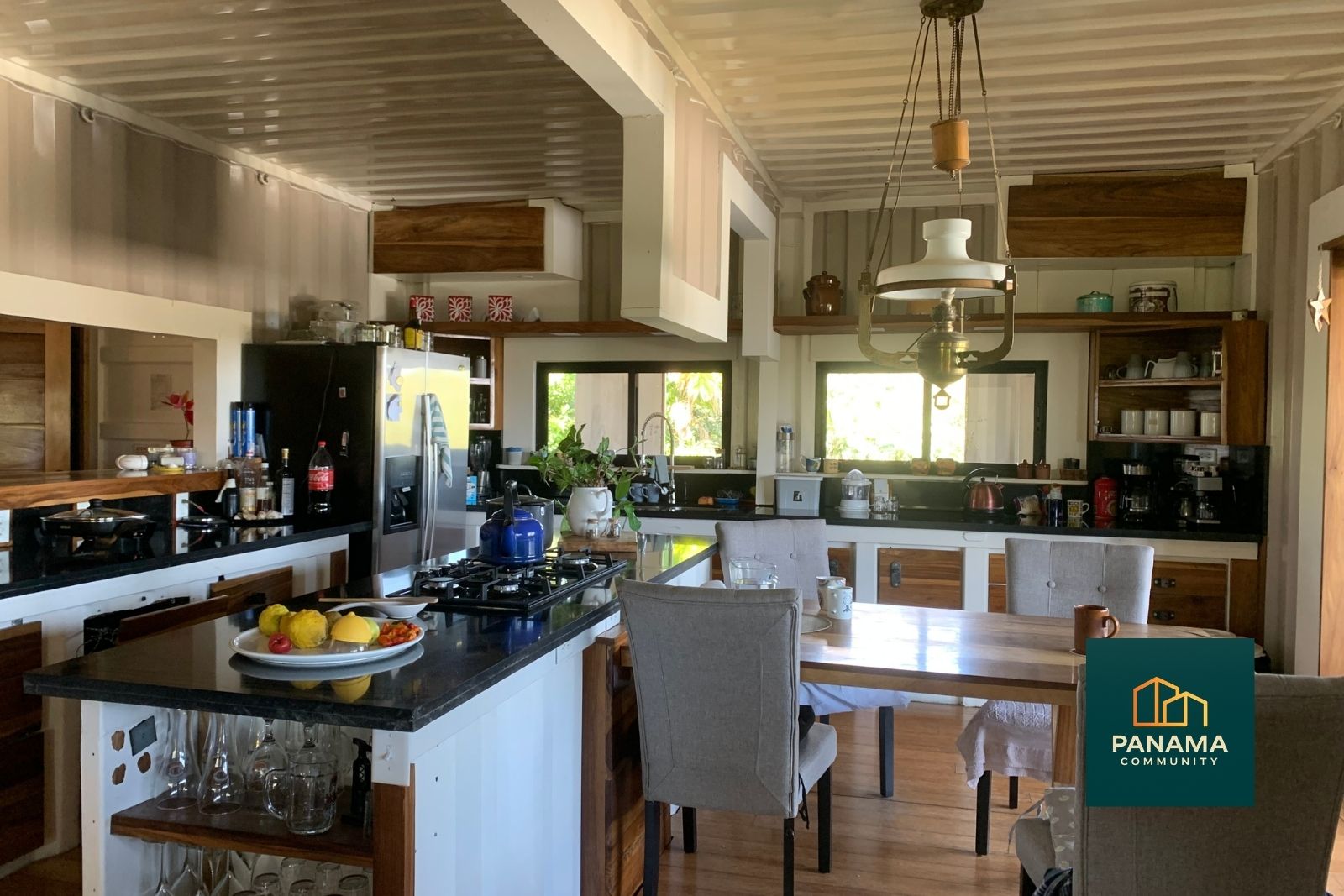 Offene Wohnküche im Obergeschoss einer Containerwohnung im Refugio de Palmira mit Kochinsel, Esstisch und viel Tageslicht